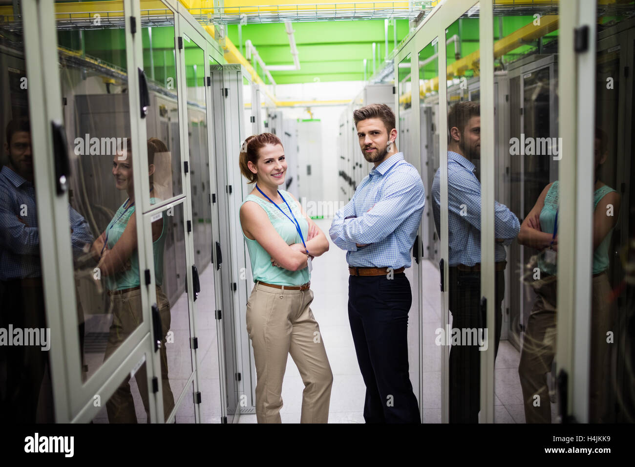 Techniker stehen mit verschränkten in einem Serverraum Stockfoto