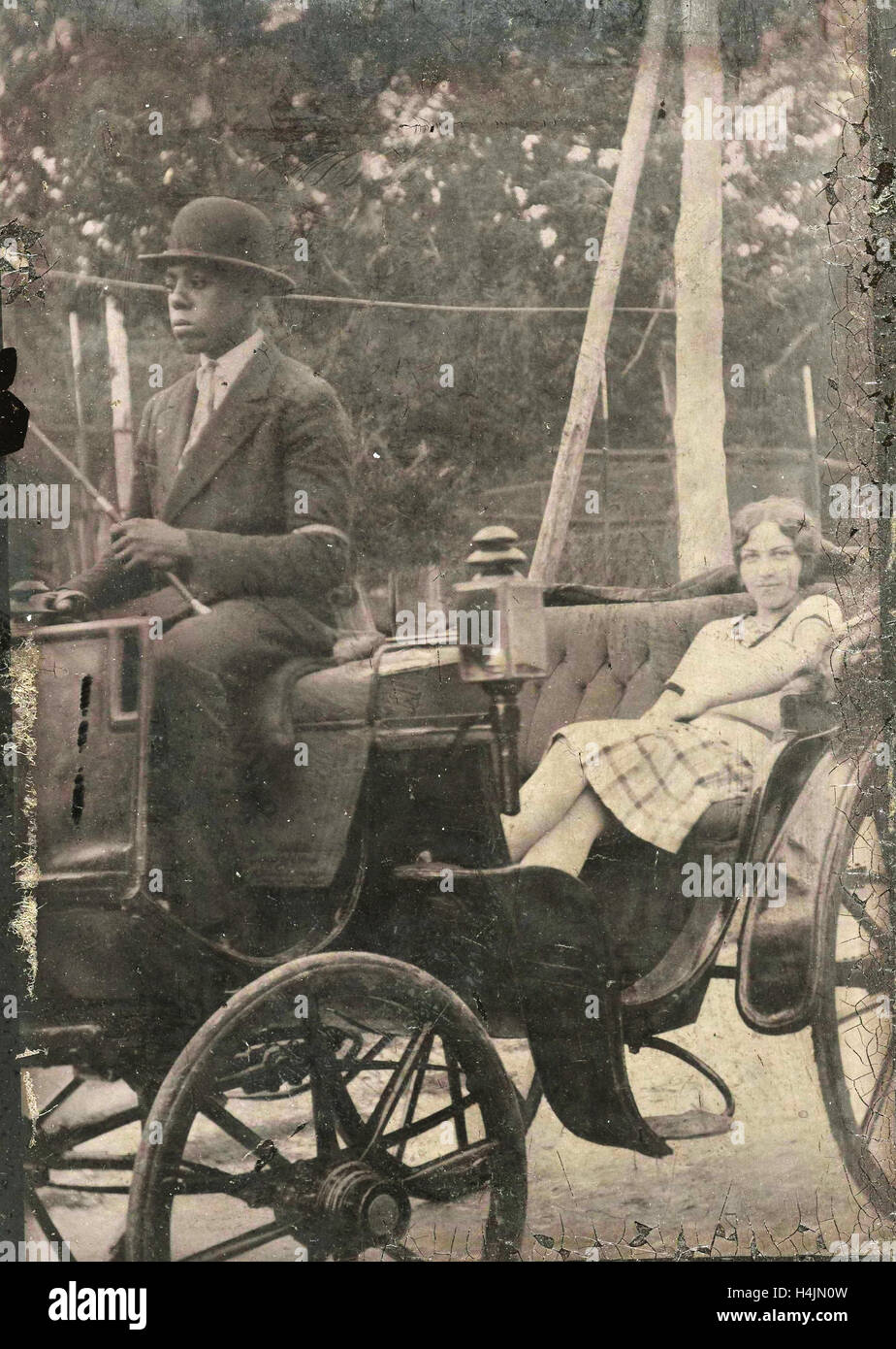 Frau sitzt in der Kutsche mit den schwarzen Peter zuschieben ein afrikanisch-amerikanischen Treiber, anonym, um 1900 - c. 1925 Stockfoto
