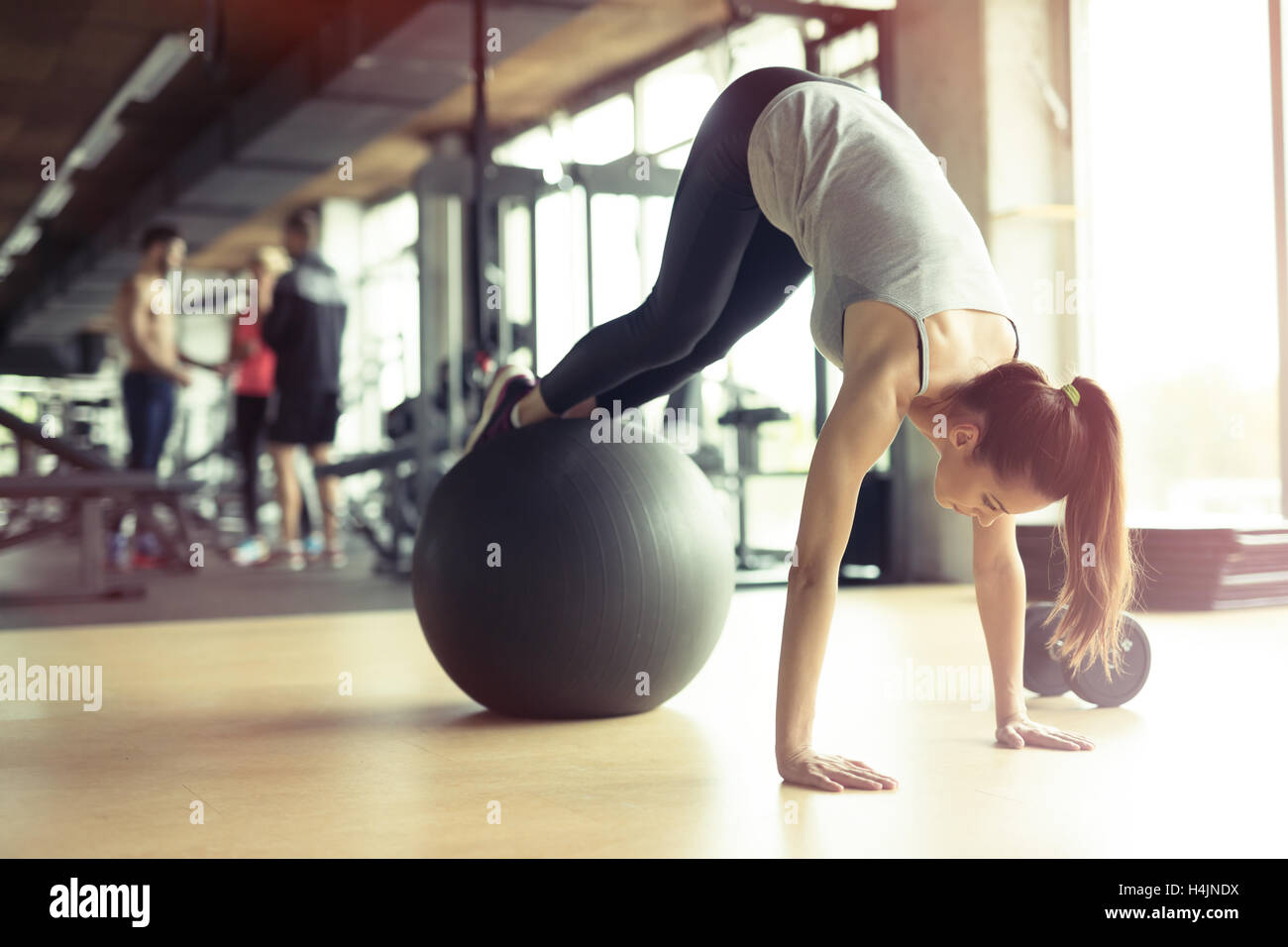 Sportliche Frau mit Ball im Fitness-Studio trainieren Stockfoto