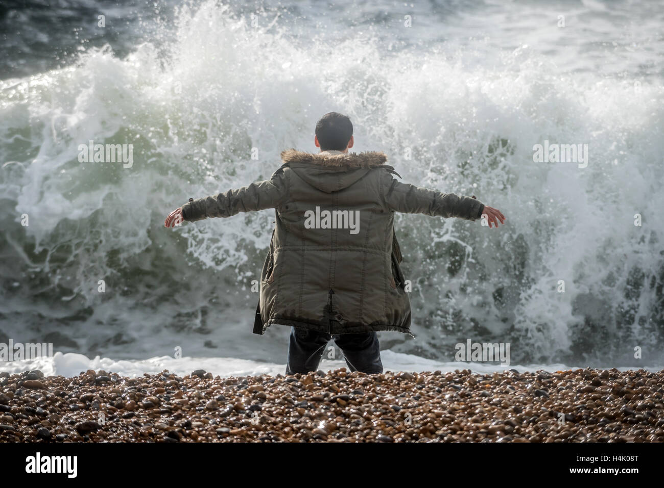 Brighton, UK. 16. Oktober 2016. Ein Mann riskiert sein eigenes Leben und dass jede mögliche Retter von wandernden ins Meer bei Flut und starkem Wind heute Morgen dort für mindestens zehn Minuten. Strandpromenade Offiziere waren aber der Mann alarmiert, die schien sich in einen Zustand der Euphorie, wanderte grinsend. Bildnachweis: Andrew Hasson/Alamy Live-Nachrichten Stockfoto