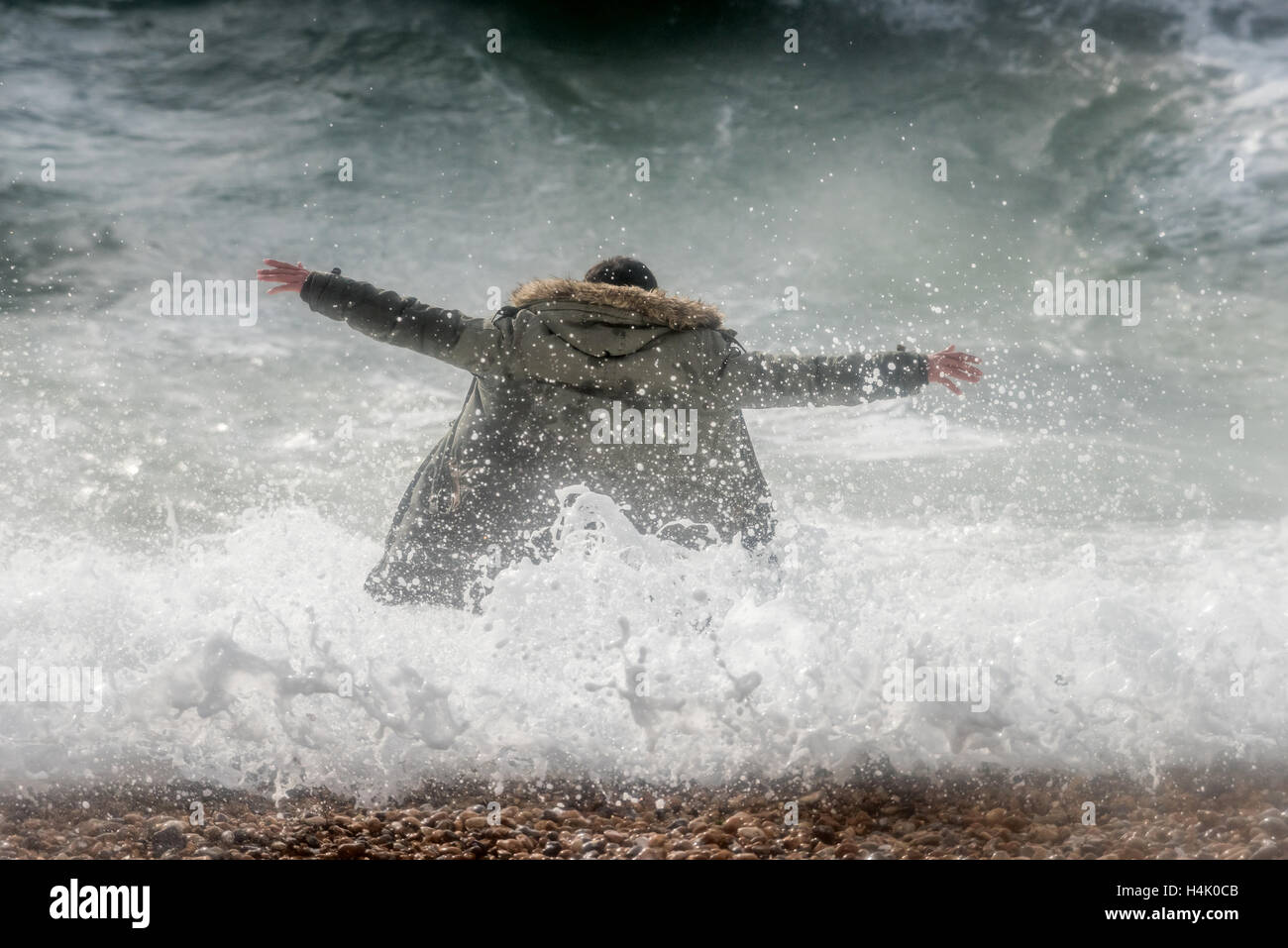 Brighton, UK. 16. Oktober 2016. Ein Mann riskiert sein eigenes Leben und dass jede mögliche Retter von wandernden ins Meer bei Flut und starkem Wind heute Morgen dort für mindestens zehn Minuten. Strandpromenade Offiziere waren aber der Mann alarmiert, die schien sich in einen Zustand der Euphorie, wanderte grinsend. Bildnachweis: Andrew Hasson/Alamy Live-Nachrichten Stockfoto