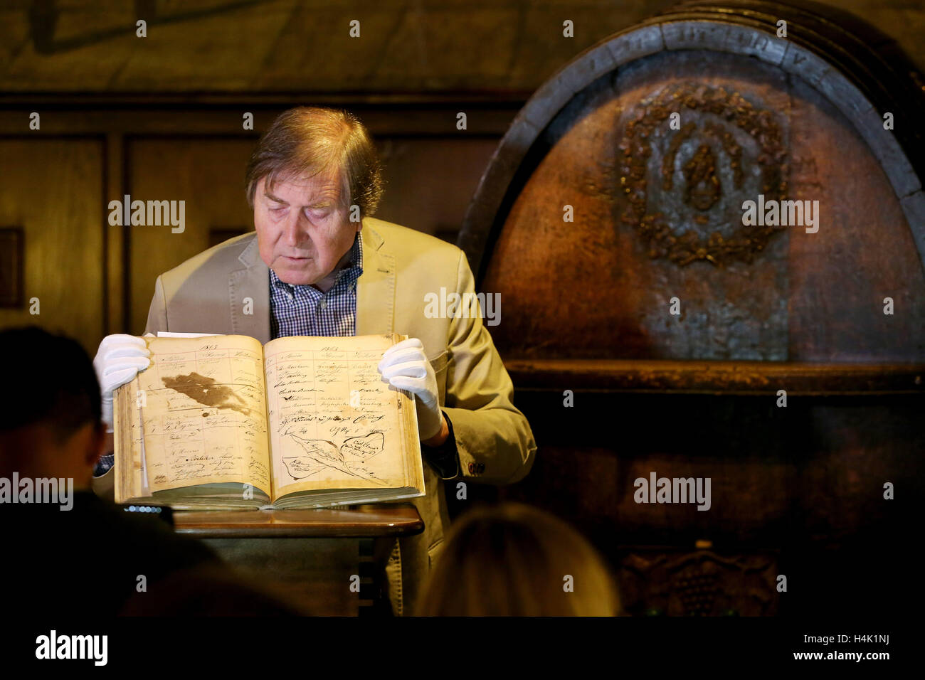 Leipzig, Deutschland. 17. Oktober 2016. Bernd Weinkauf, Historiker, präsentiert eine historische Gästebuch aus der traditionellen "Auerbachs Keller" Hall in Leipzig, Deutschland, 17. Oktober 2016. Die Band stammt aus dem Jahre 1859 bis 1866 enthält die Einträge der zahlreichen Gäste. Die Einträge wurden "Dutzende von Bismarck, mehrere von Goethe und von Napoleon III.," sagt der Haus-Historiker, "Denken Sie daran, die Alkohol beteiligt war!". Es gibt Unterschrift des Komponisten Edvard Grieg die Weinkauf übernimmt, um authentisch zu sein. Das Gästebuch seit zwei Jahrzehnten verschwunden, aber jetzt erschien in einer prin Stockfoto