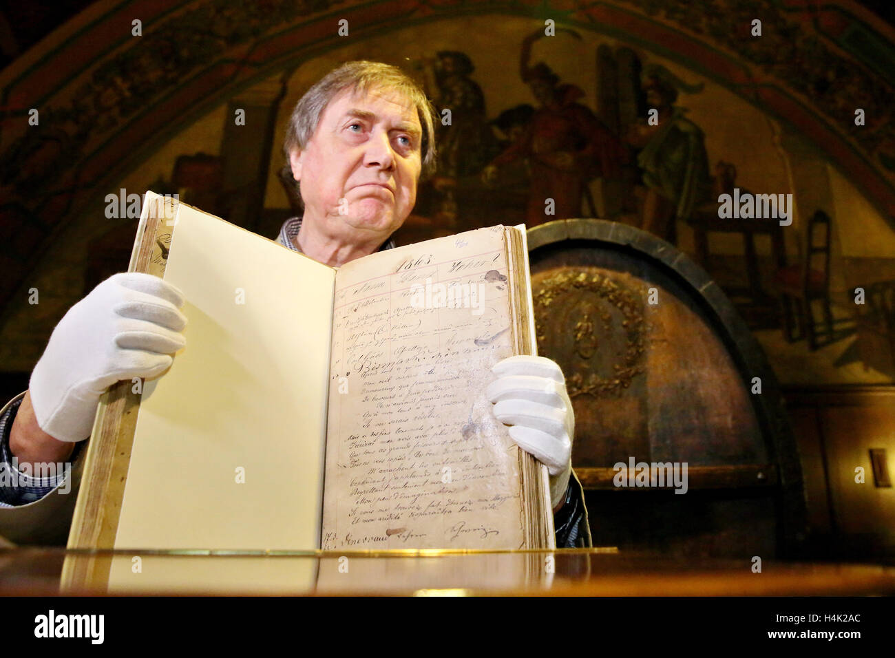 Bernd Weinkauf, Historiker, präsentiert eine historische Gästebuch aus der traditionellen "Auerbachs Keller" Hall in Leipzig, Deutschland, 17. Oktober 2016. Die Band stammt aus dem Jahre 1859 bis 1866 enthält die Einträge der zahlreichen Gäste. Die Einträge wurden "Dutzende von Bismarck, mehrere von Goethe und von Napoleon III.," sagt der Haus-Historiker, "Denken Sie daran, die Alkohol beteiligt war!". Es gibt Unterschrift des Komponisten Edvard Grieg die Weinkauf übernimmt, um authentisch zu sein. Das Gästebuch seit zwei Jahrzehnten verschwunden, aber jetzt erschien in einer Druckerei in Nordrhein-Westfalen. Stockfoto