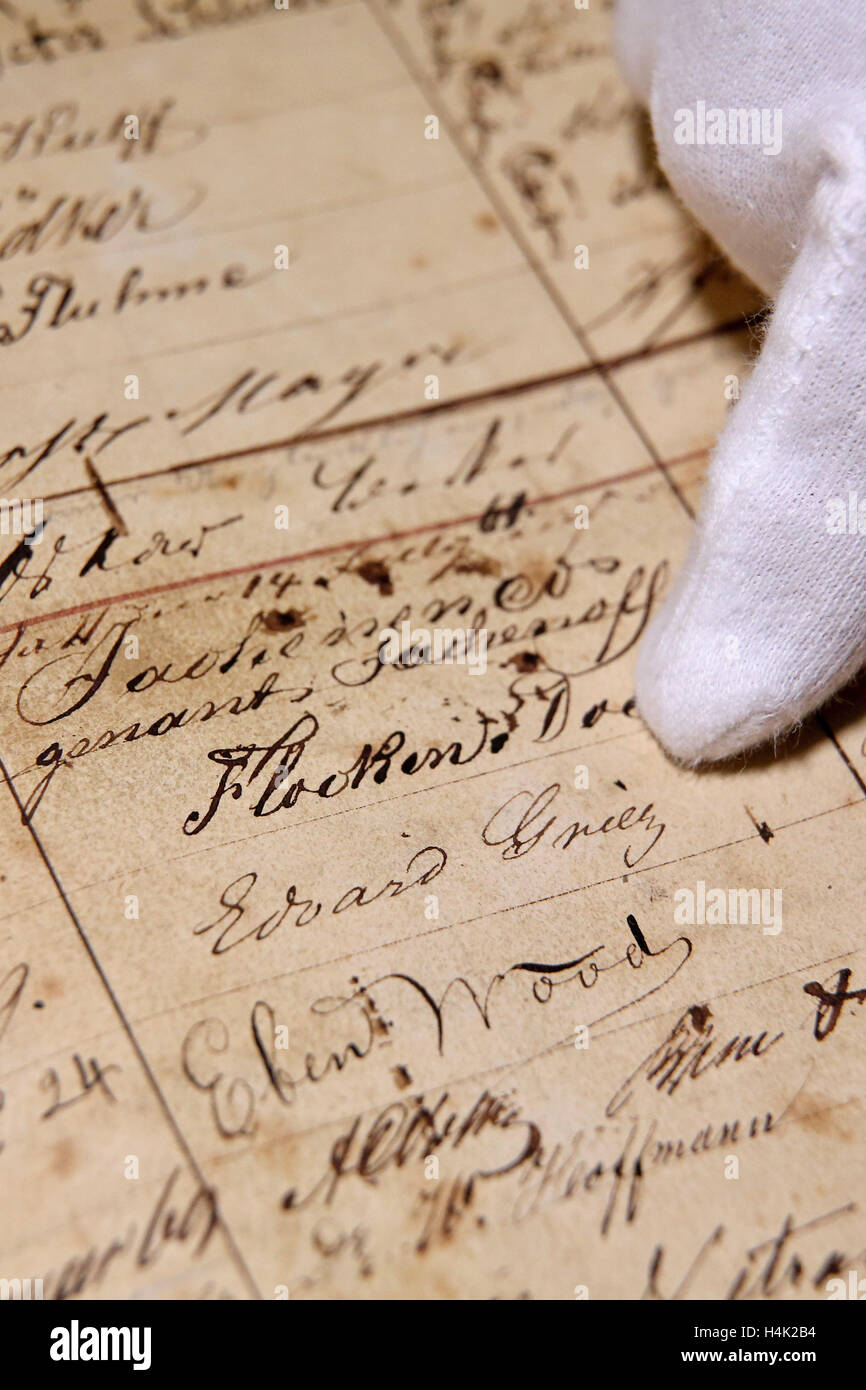 Bernd Weinkauf, Historiker, präsentiert eine historische Gästebuch aus der traditionellen "Auerbachs Keller" Hall in Leipzig, Deutschland, 17. Oktober 2016. Die Band stammt aus dem Jahre 1859 bis 1866 enthält die Einträge der zahlreichen Gäste. Die Einträge wurden "Dutzende von Bismarck, mehrere von Goethe und von Napoleon III.," sagt der Haus-Historiker, "Denken Sie daran, die Alkohol beteiligt war!". Es gibt Unterschrift des Komponisten Edvard Grieg die Weinkauf übernimmt, um authentisch zu sein. Das Gästebuch seit zwei Jahrzehnten verschwunden, aber jetzt erschien in einer Druckerei in Nordrhein-Westfalen. Stockfoto