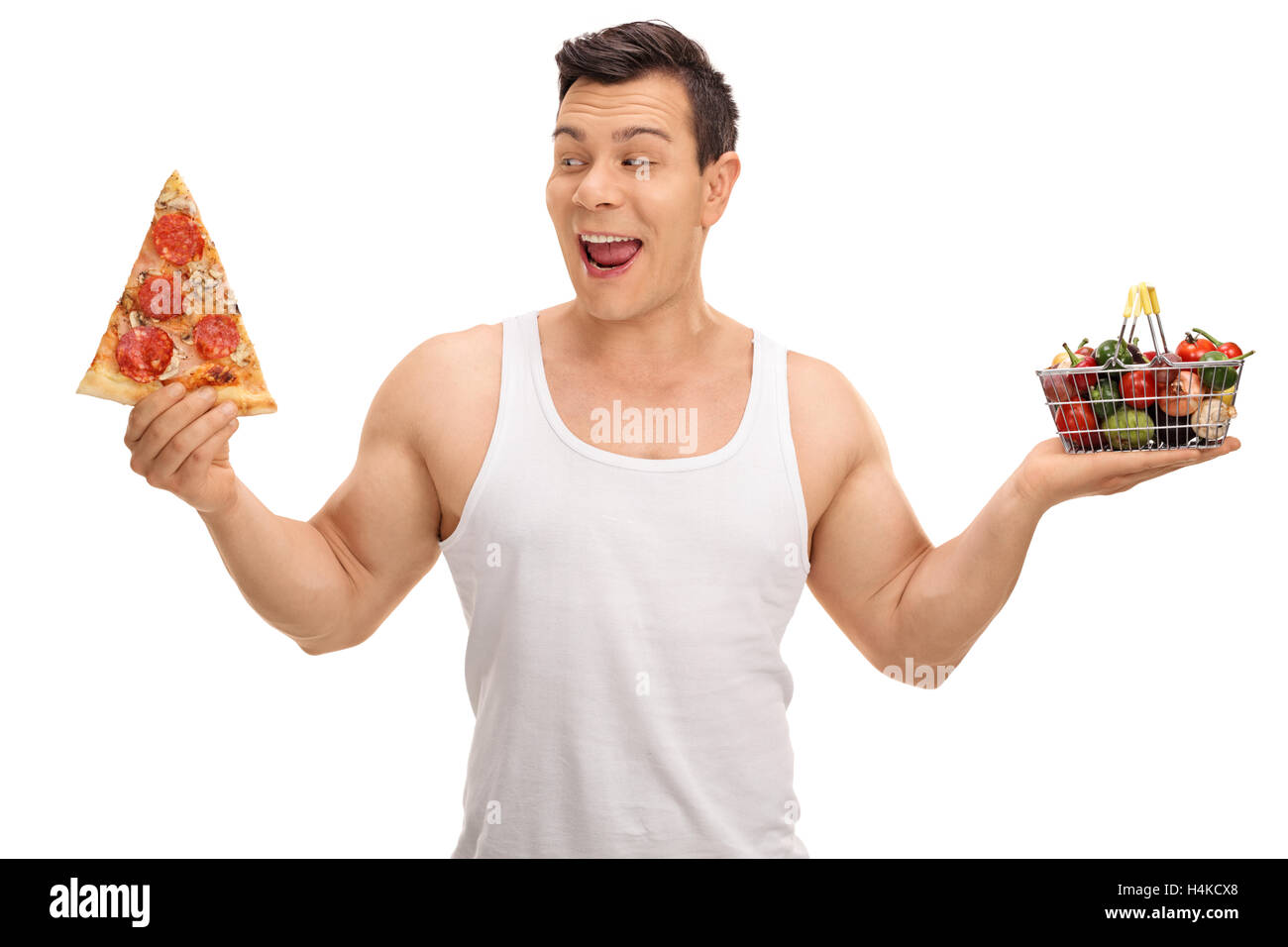 Versucht Mann hält ein Pizzastück und einen kleinen shopping Korb voller Früchte und Gemüse isoliert auf weißem Hintergrund Stockfoto
