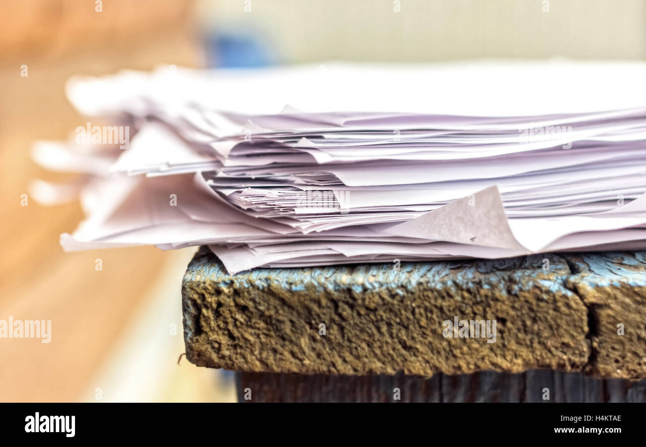 Weiße Stapel Papierblätter auf blauer Schreibtisch aus Holz Stockfoto