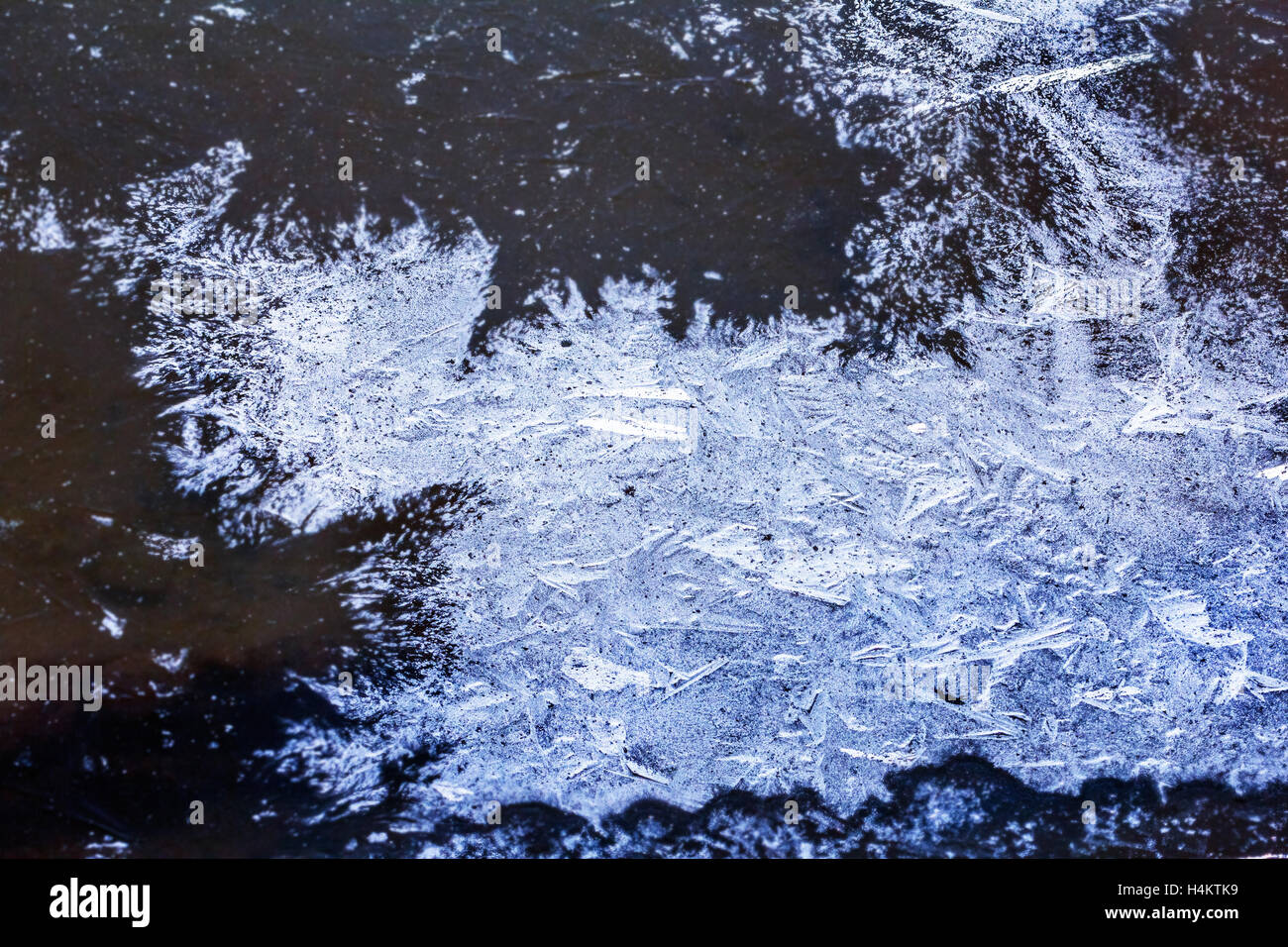 Blaues Eis auf dem dunklen Wasser am Wintertag Stockfoto