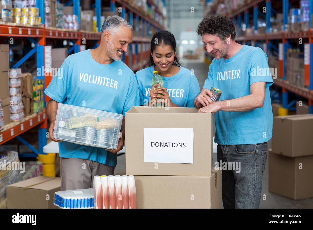 Drei Freiwillige, die Nahrungsmittel in Karton Verpackung Stockfoto