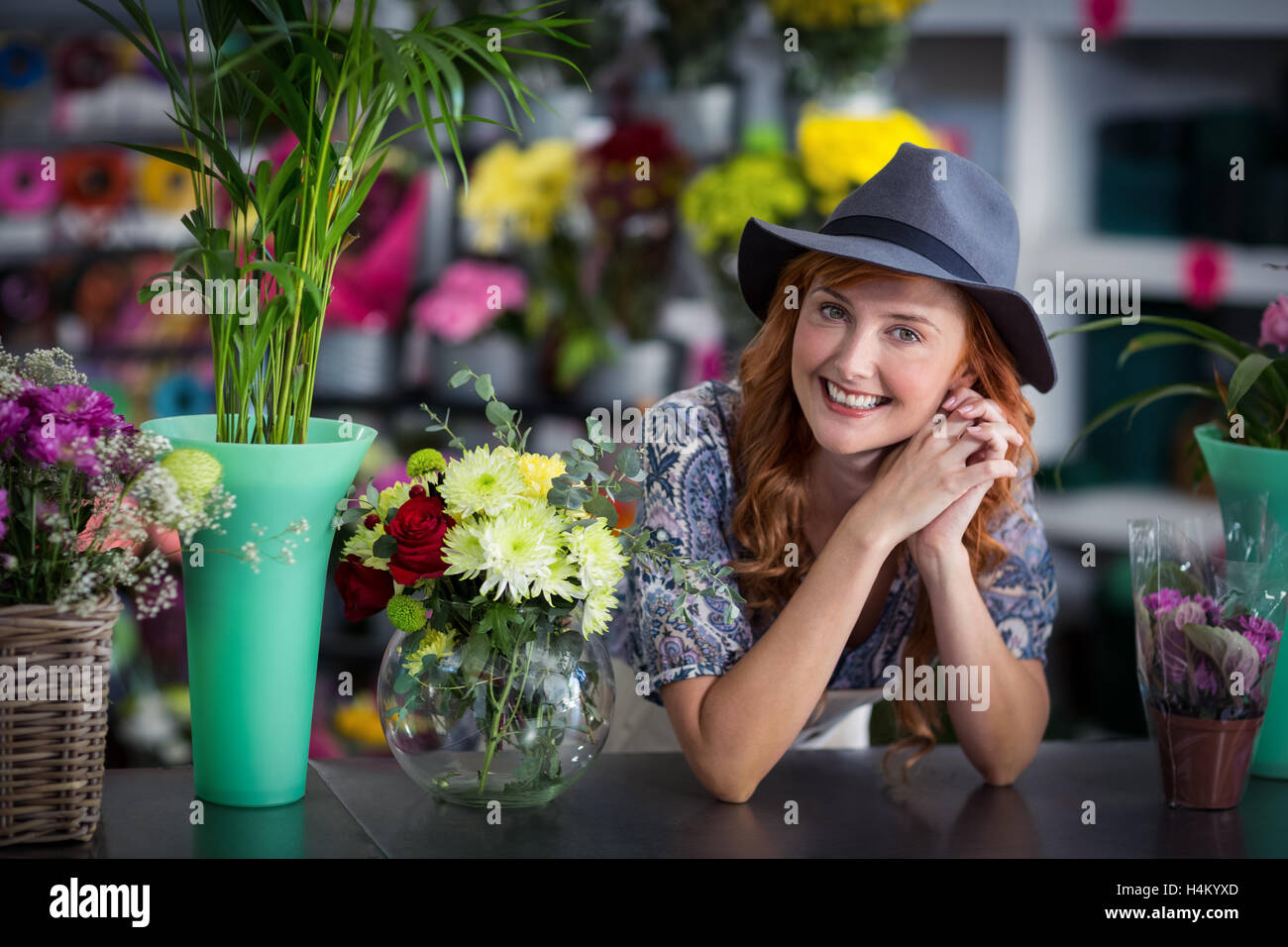 Glücklich weibliche Florist stützte sich im Blumenladen Stockfoto