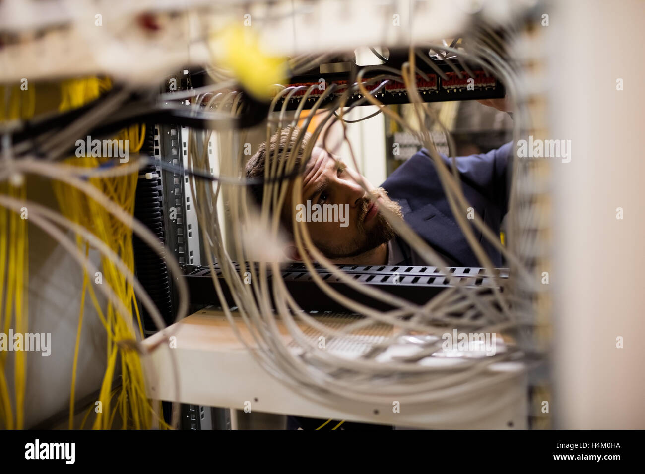 Techniker überprüfen Kabel in einem Rack montiert server Stockfoto