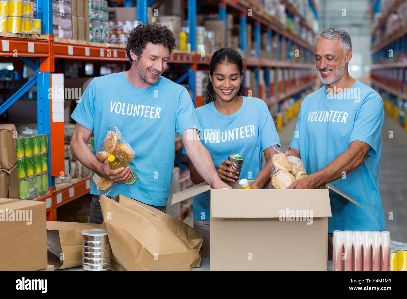 Drei Freiwillige, die Nahrungsmittel in Karton Verpackung Stockfoto