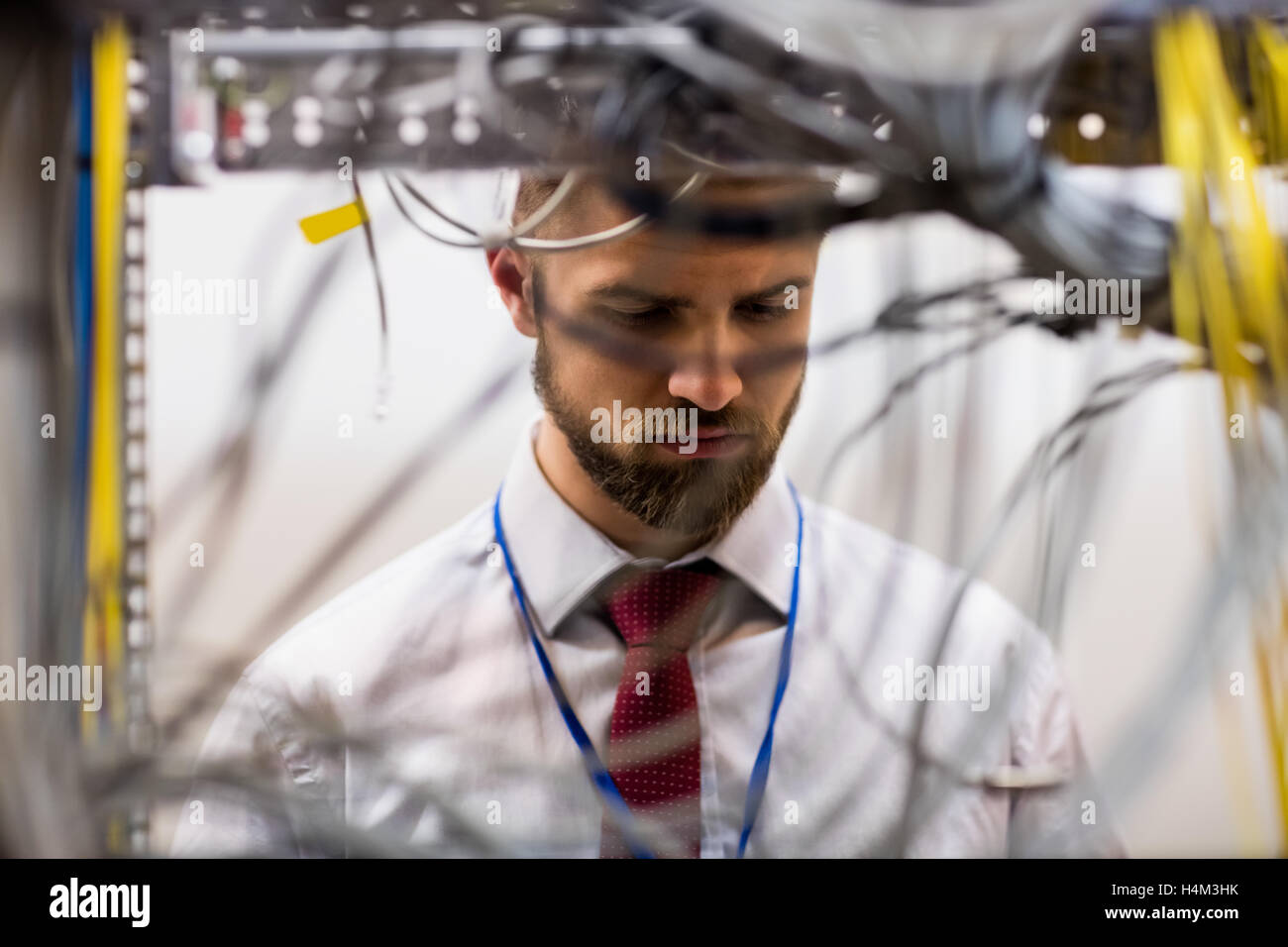 Techniker überprüfen Kabel in einem Rack montiert server Stockfoto