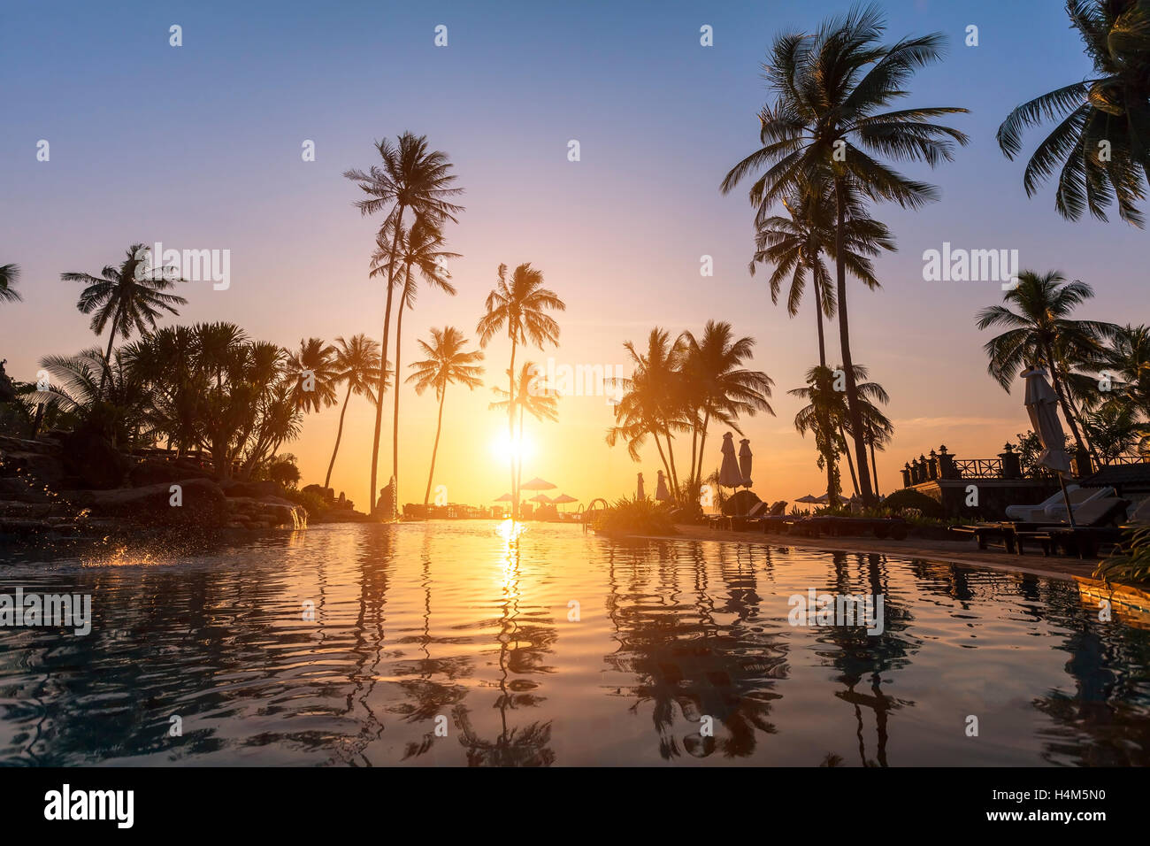 Luxury Beach Hotel, Silhouette mit Palmen, Pool, ein schöner Sonnenuntergang Stockfoto