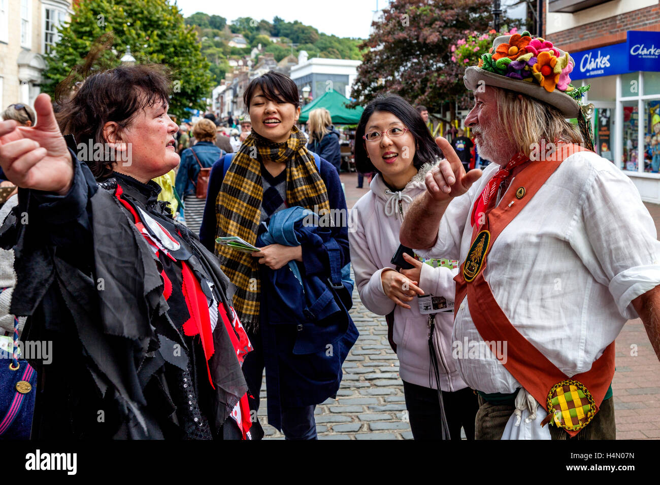 Traditionellen Morris Tänzer In Tracht chatten mit japanischen Touristen bei Lewes Folk Festival 2016, Lewes, Sussex, UK Stockfoto