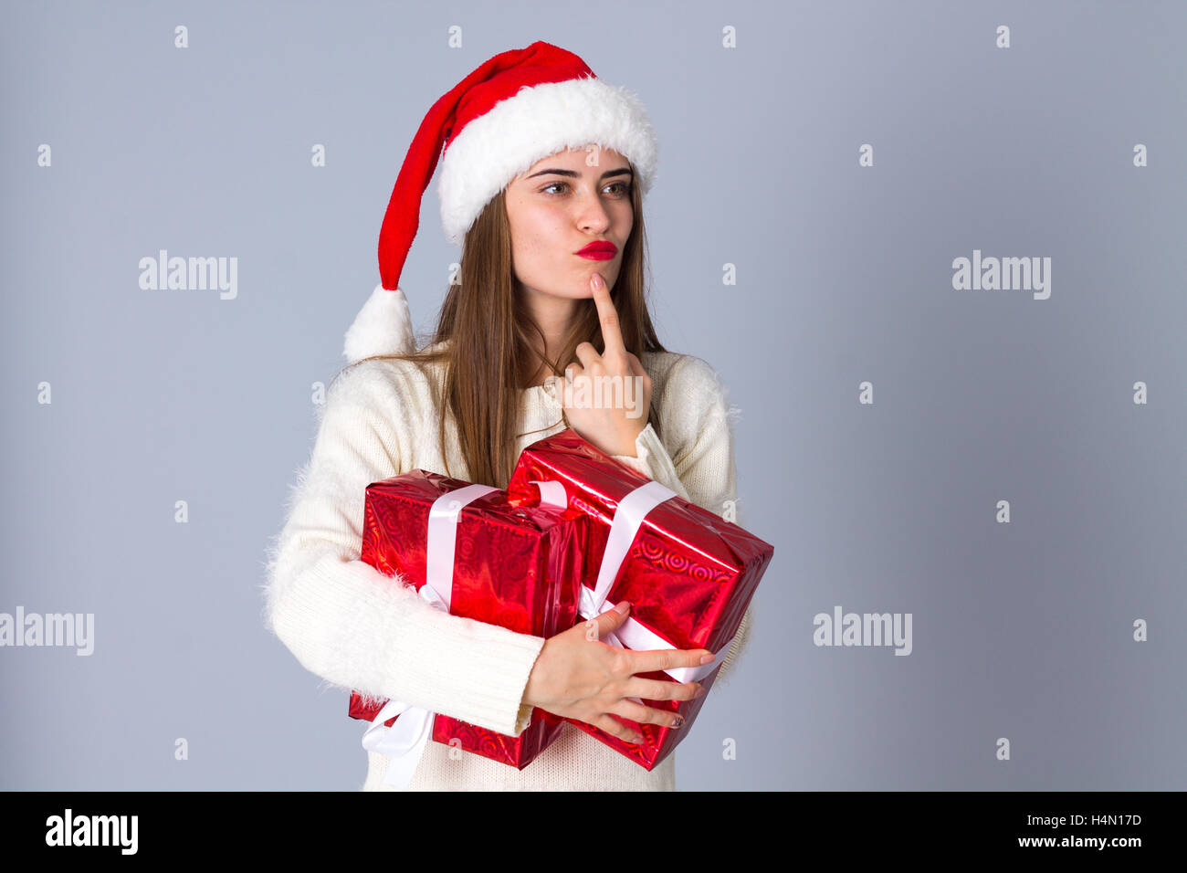 Frau in rot Weihnachtsmütze hält Geschenke Stockfoto
