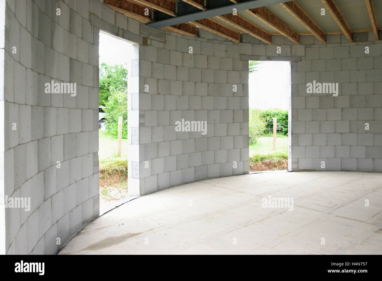 Innenraum eines kreisförmigen Haus im Bau in Whitstable, Großbritannien. Zeigt Betonsteine, Holz Balken und Stahlträger Stockfoto