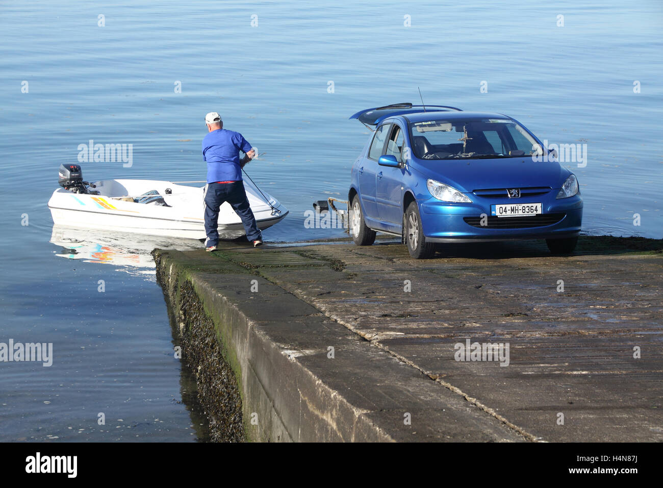 Man startet ein kleines Motorboot an Holmes Quay County Louth, Irland Stockfoto