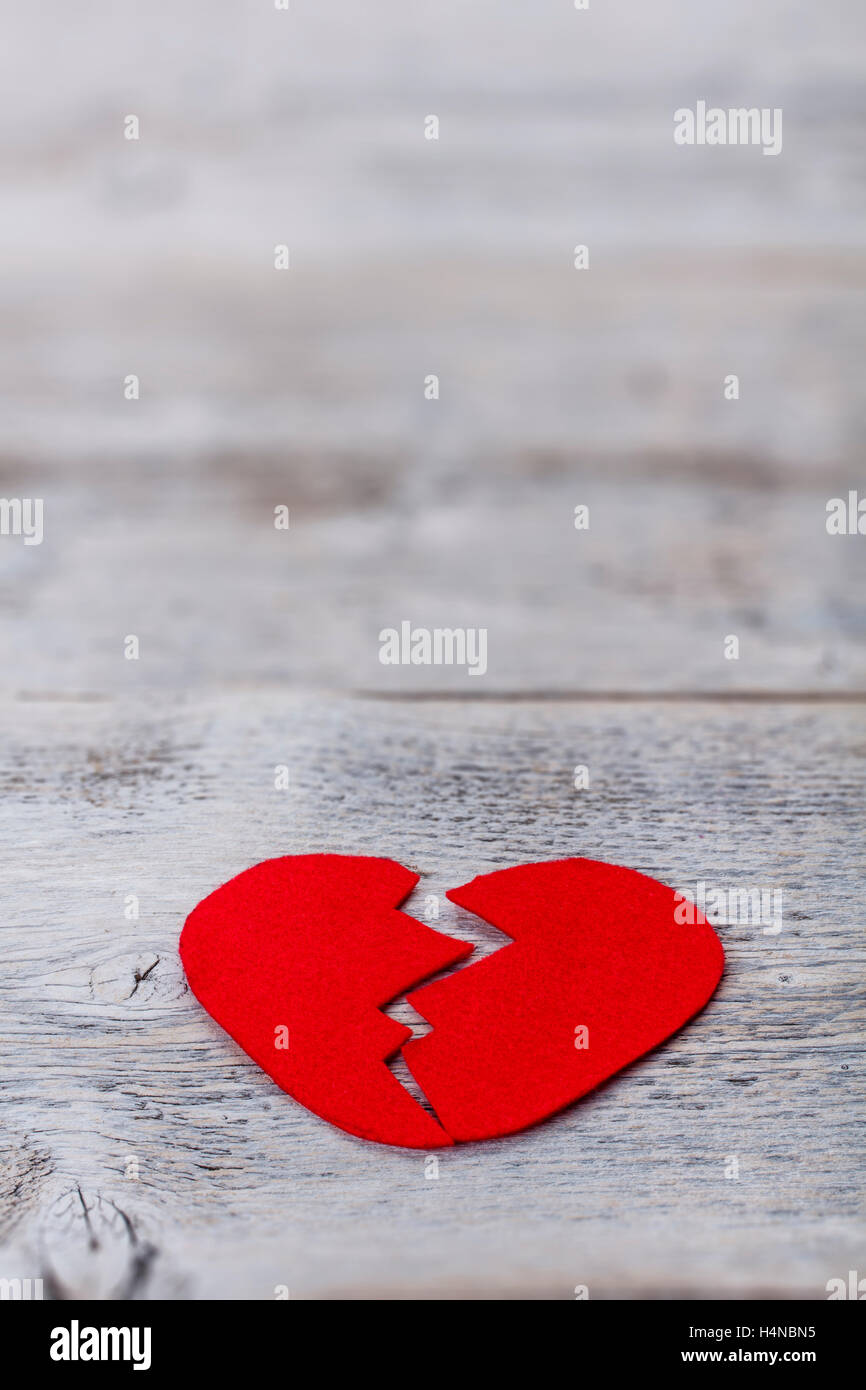 Roten Filzes Herz auf hölzernen Hintergrund gebrochen Stockfoto