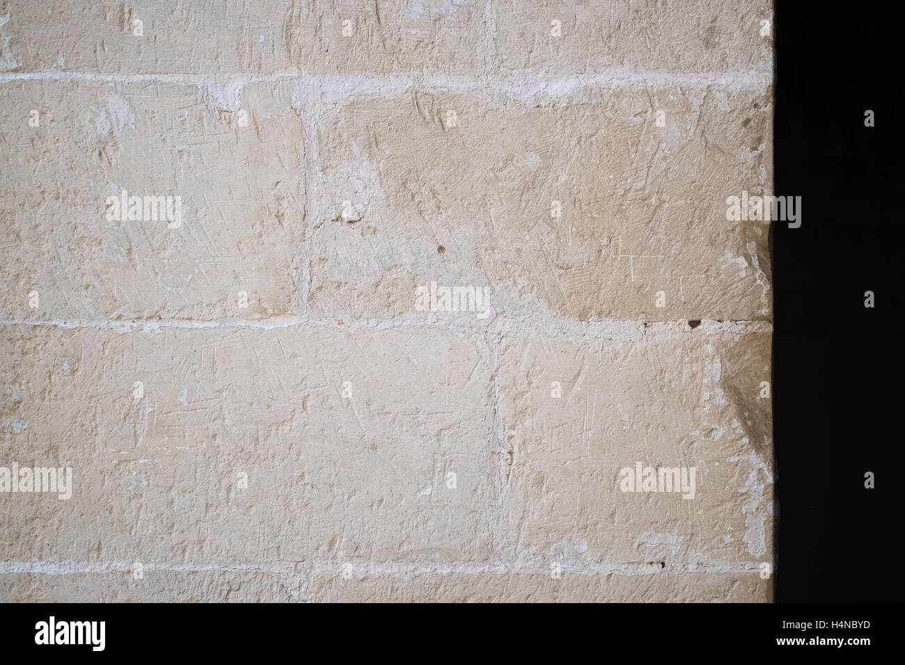 Traditionellen weißen Steinmauer. Detail von einer Wand aus weißem Kalkstein Ziegel. Sichtbare Spuren der Meißel. Stockfoto