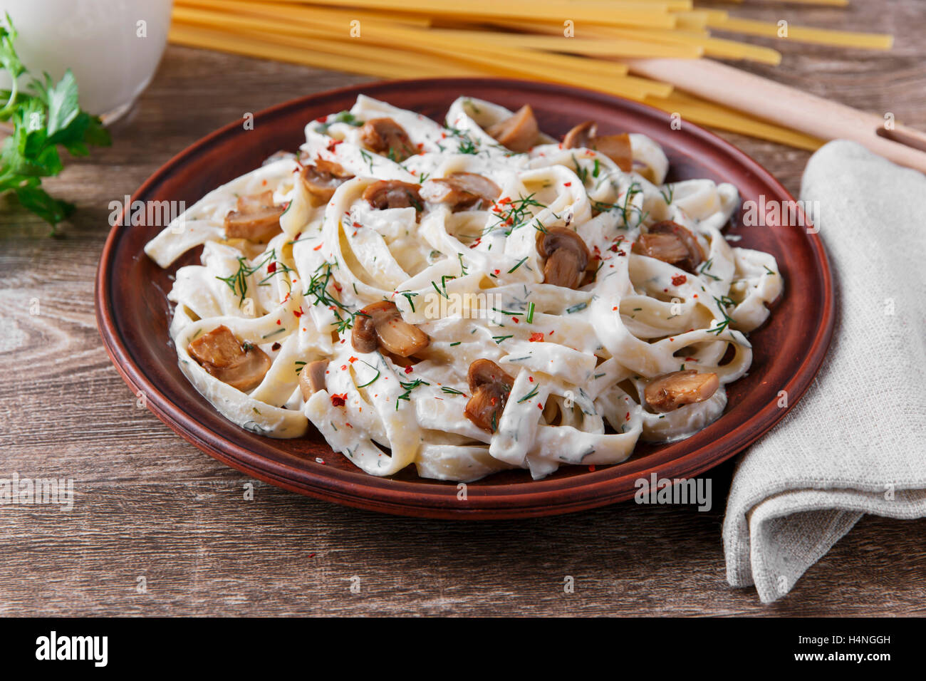 Nudeln mit Käse und gebratenen Pilzen in weißer Soße Stockfoto