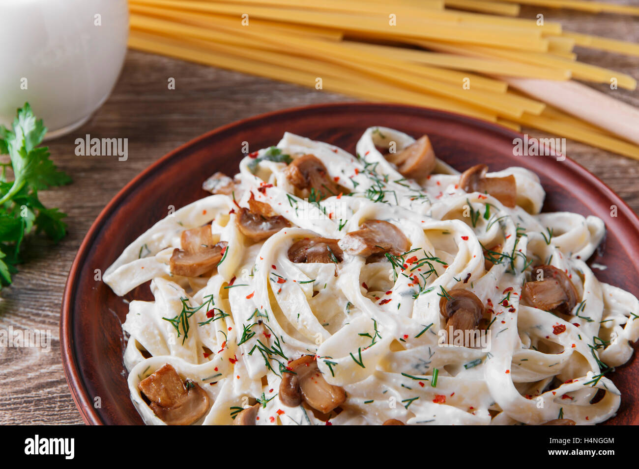 Nudeln mit Käse und gebratenen Pilzen in weißer Soße Stockfoto