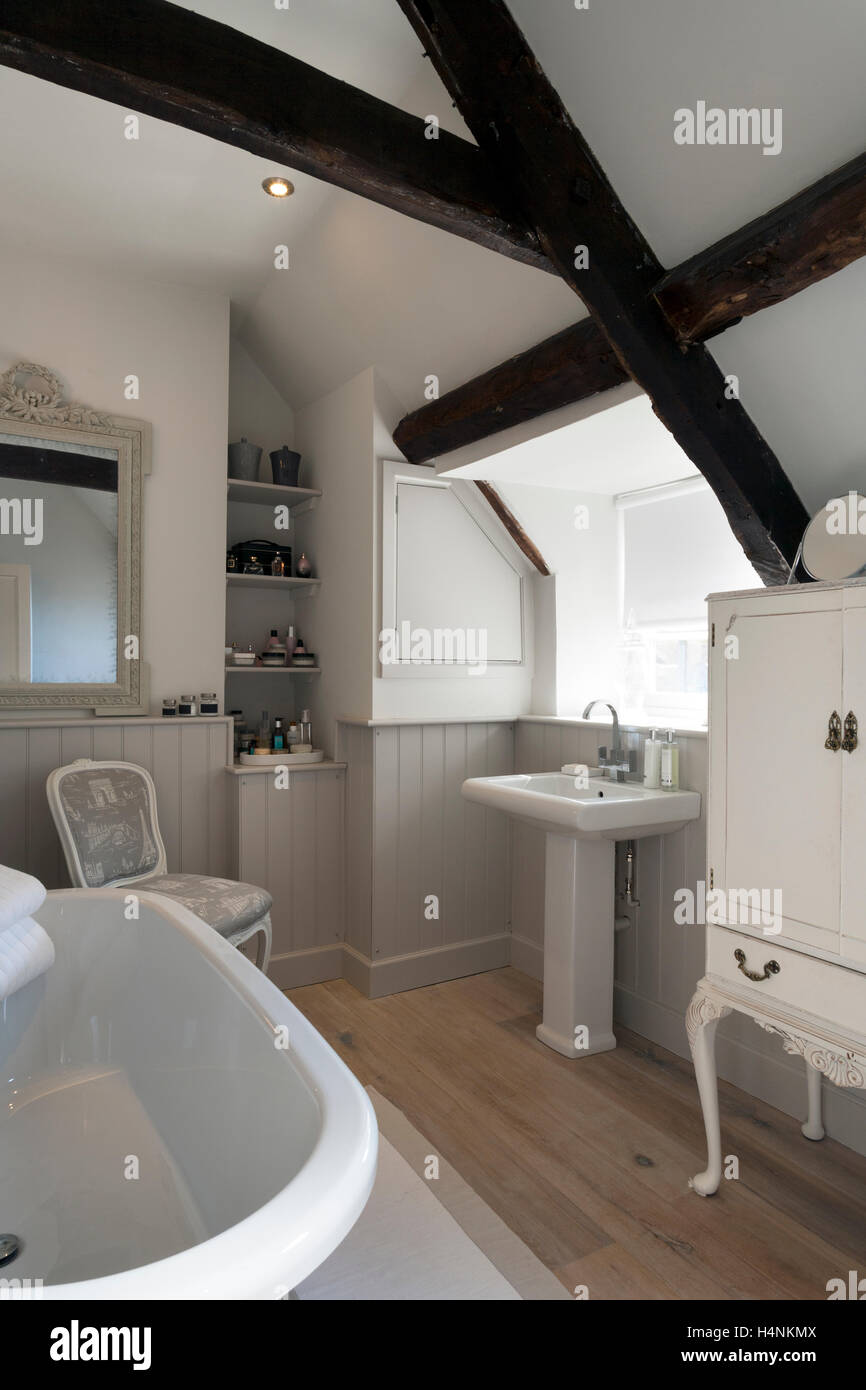 Eine kleine Dachgeschoss Badezimmer mit Balken, lackierte Verkleidung und einem Sockel. Stockfoto