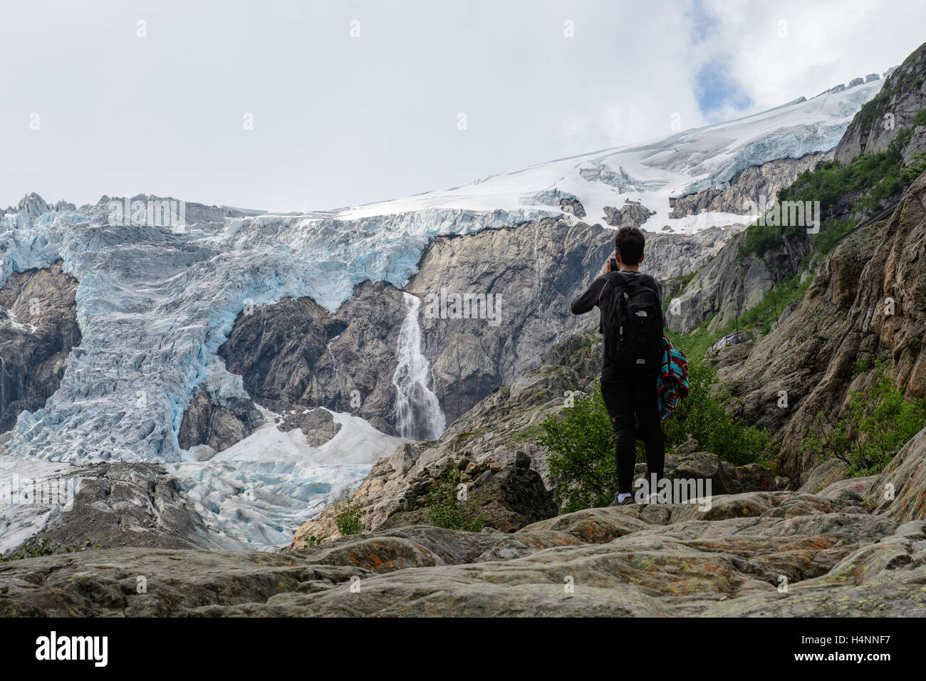Touristen nehmen Foto mit Smartphone von den Buerbreen Gletscher Folgefonna Nationalpark, Norwegen Stockfoto