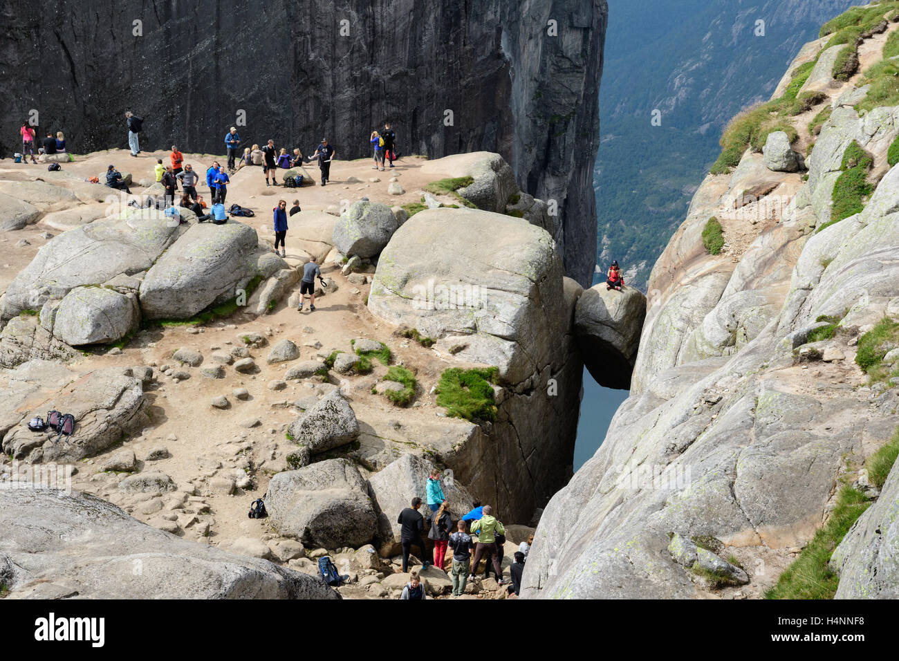 Touristen am Kjerag, einem Felsen hängen 1100 Meter über dem Fjord Lysefjord, Norwegen Stockfoto