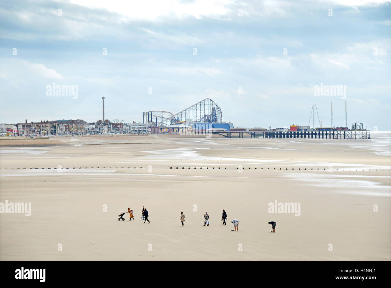 Eine Familiengruppe Spaziergänge am Strand entlang zwischen Central Pier und The Pleasure Beach Blackpool, England. Stockfoto