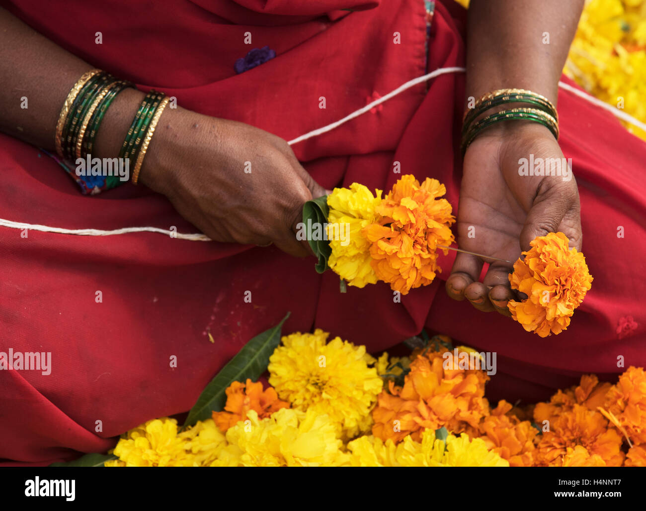 Das Bild der Frau, Herstellung und Verkauf von Girlanden auf Dadar Markt, Mumbai, Indien Stockfoto