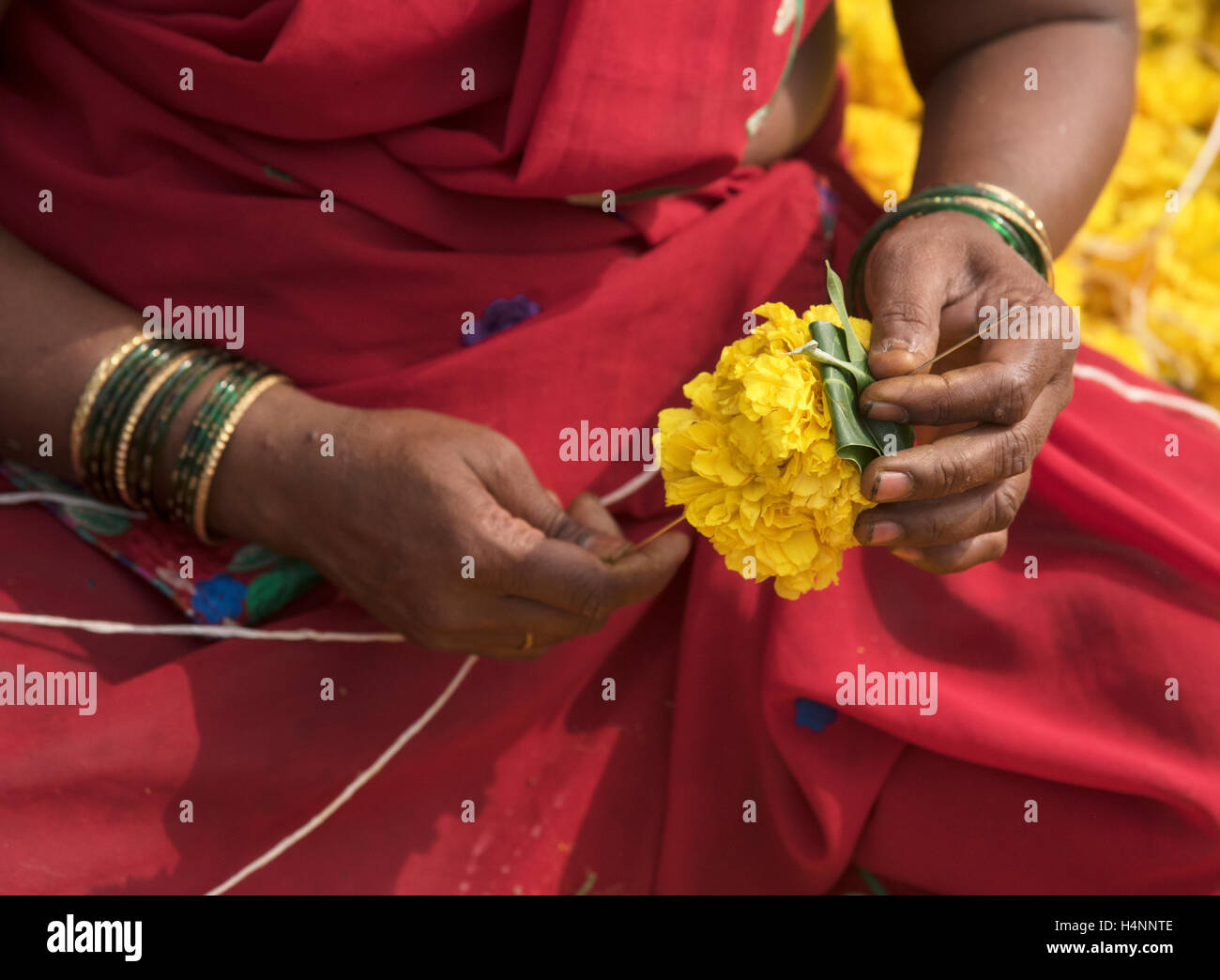 Das Bild der Frau, Herstellung und Verkauf von Girlanden auf Dadar Markt, Mumbai, Indien Stockfoto