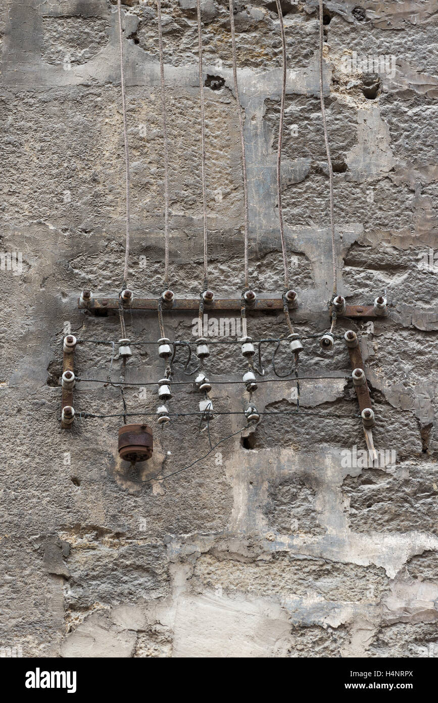 alte elektrische Anschlüsse auf einer Steinmauer Stockfoto
