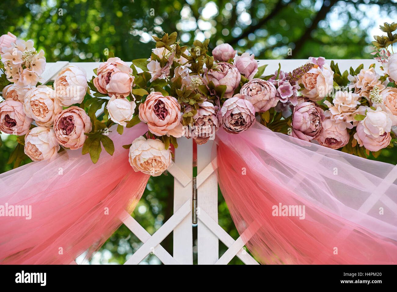 Schöne weiße Hochzeit Bogen dekoriert mit rosa und rote Blüten im freien Stockfoto