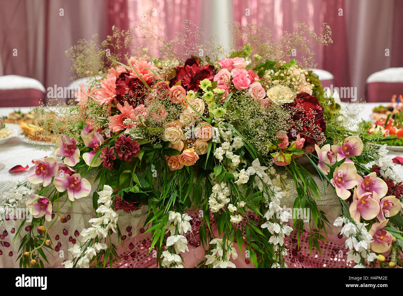 Schöne weiße Hochzeit Bogen dekoriert mit rosa und rote Blüten im freien Stockfoto