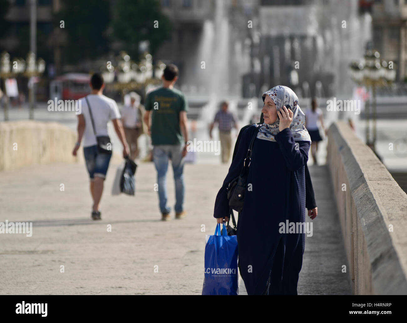 Muslimische Frauen zu Fuß über die steinerne Brücke, am Telefon zu sprechen. Skopje, Mazedonien Stockfoto