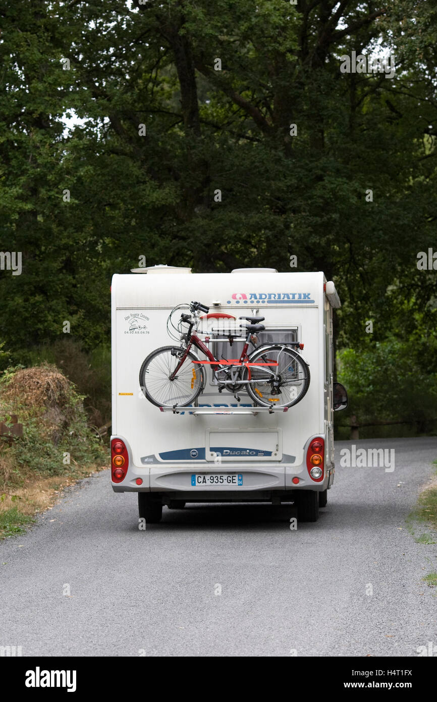 Wohnmobil auf einer französischen Landstraße mit Fahrrädern auf der Rückseite. Stockfoto