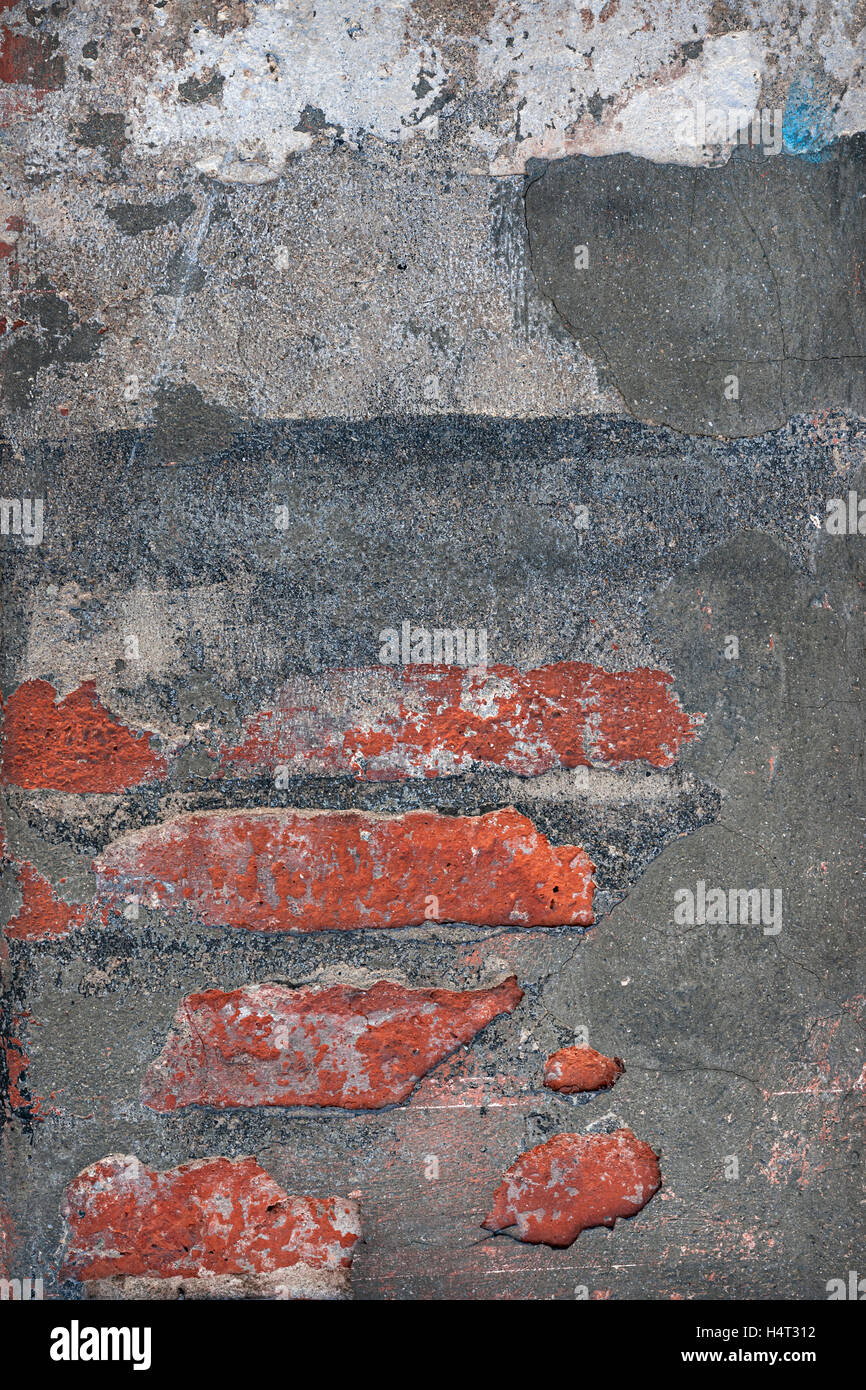 Zusammenfassung Hintergrund aus rotem Ziegelstein zeigt aber Schichten aus Zement und Gips. Gebäude-Fragment in Toulouse, Frankreich. Stockfoto