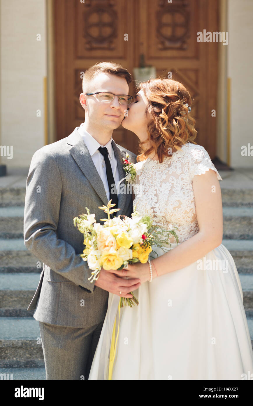 Braut und Bräutigam auf dem Hintergrund der schönen Kirche.  Altbau. Arch-Hochzeit Stockfoto