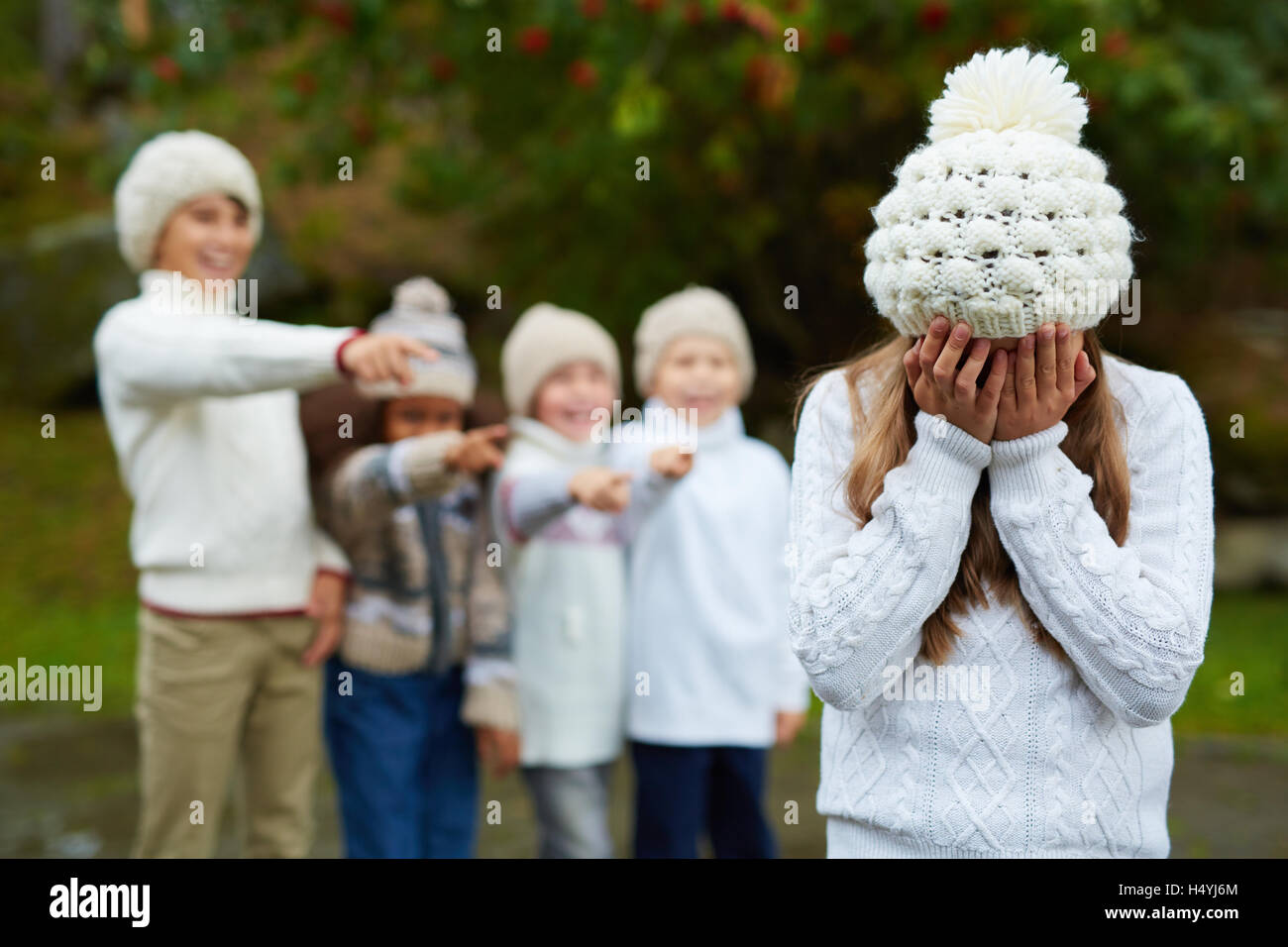 Aufgeregt Mädchen weint während Gruppe von Kinder ihr Mobbing Stockfoto