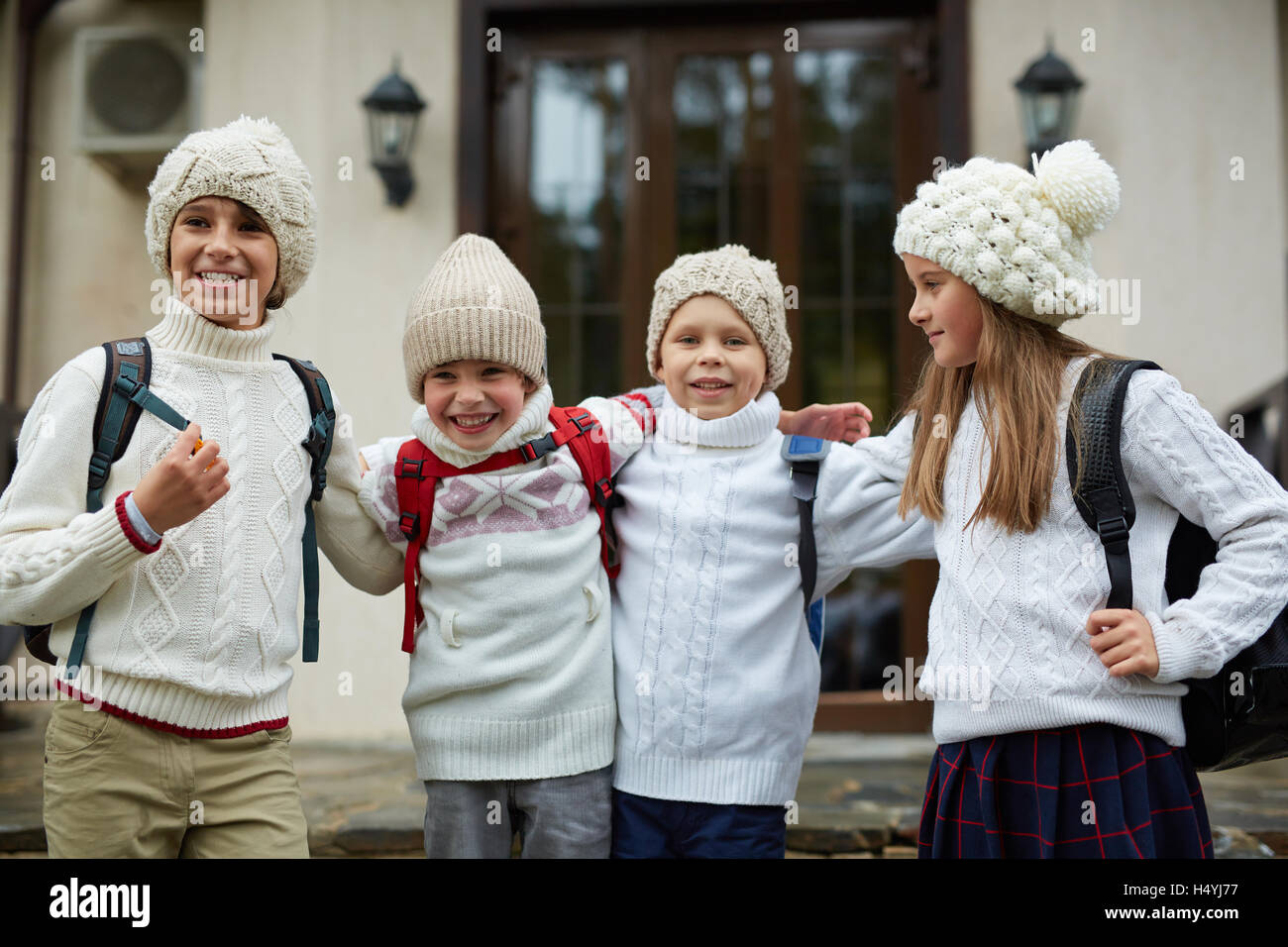 Unbeschwerte Kinder in ihrer Schule gestrickte Casual-Wear stehen Stockfoto