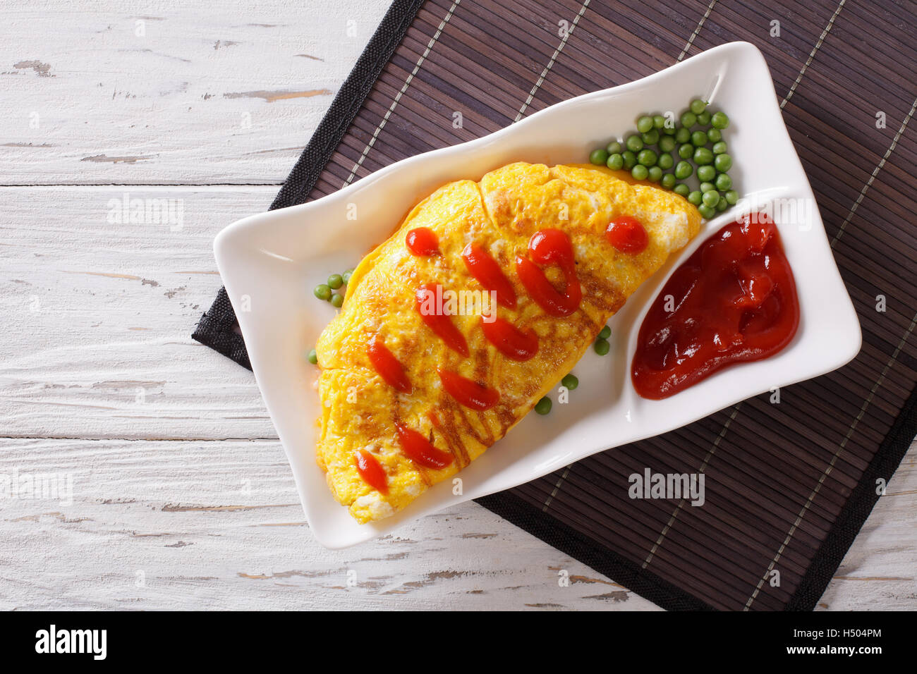 Japanische Omurice Omelette gefüllt mit Reis und Huhn auf einem Teller. horizontale Ansicht von oben Stockfoto