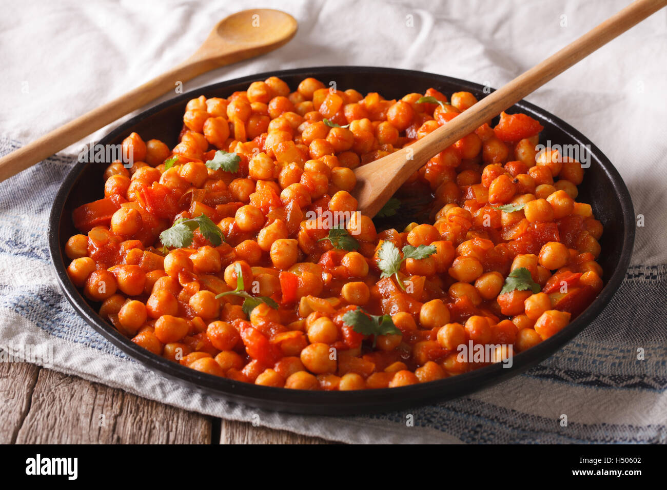 Indisches Essen: Kichererbsen in Curry-Sauce mit einer Tabelle Großaufnahme. Horizontale Stockfoto