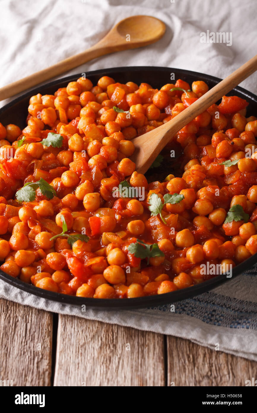 Indisches Essen: Kichererbsen in Curry-Sauce mit einer Großaufnahme Teller auf den Tisch. vertikale Stockfoto