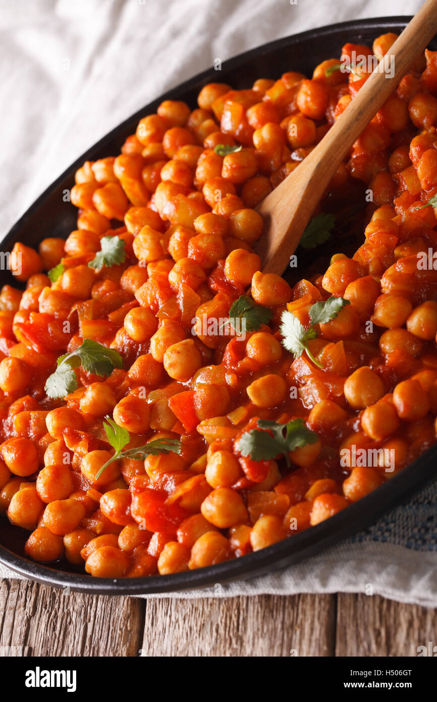 Indische Küche: Kichererbsen in Tomatensauce mit Gewürzen Nahaufnahme auf dem Tisch. vertikale Stockfoto