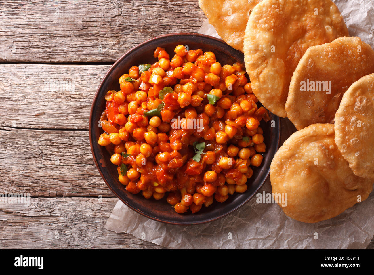 Köstliche indische Chana Masala und Puri Brot auf dem Tisch. Horizontale Ansicht von oben Stockfoto