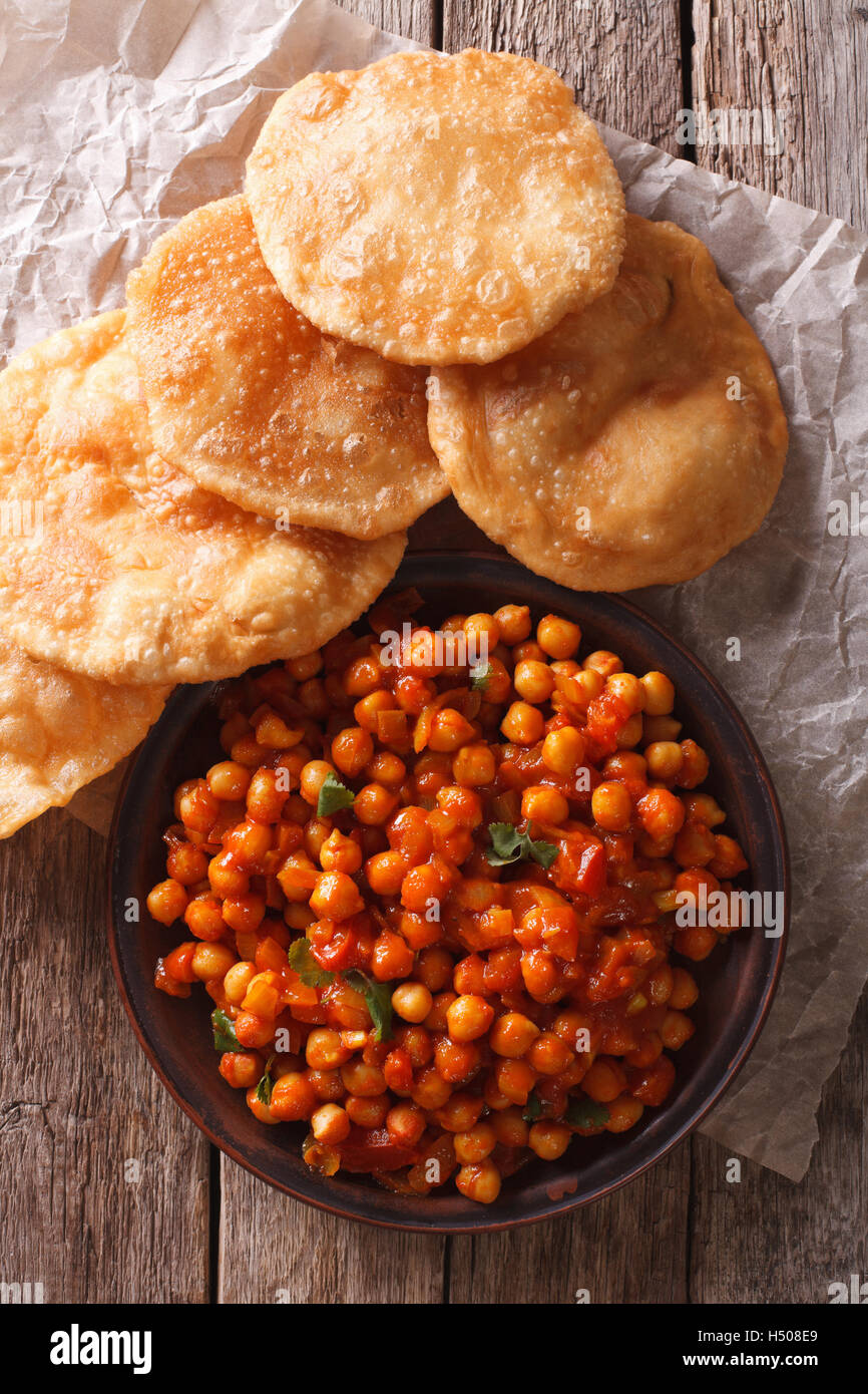 Köstliche indische Chana Masala und Puri Brot close-up auf dem Tisch. Vertikale Ansicht von oben Stockfoto