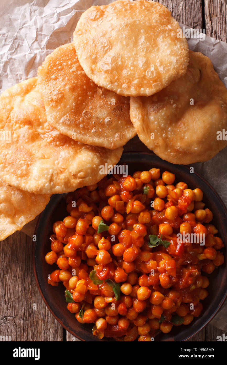 Indische Chana Masala und Puri Brot close-up auf dem Tisch. Vertikale Ansicht von oben Stockfoto