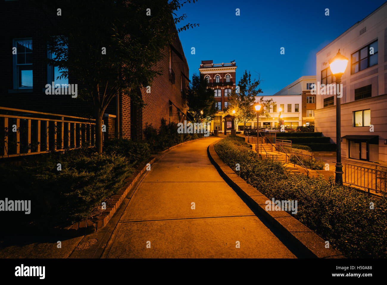 Gehweg und Gebäude in der Nacht in der Innenstadt von Rock Hill, South Carolina. Stockfoto