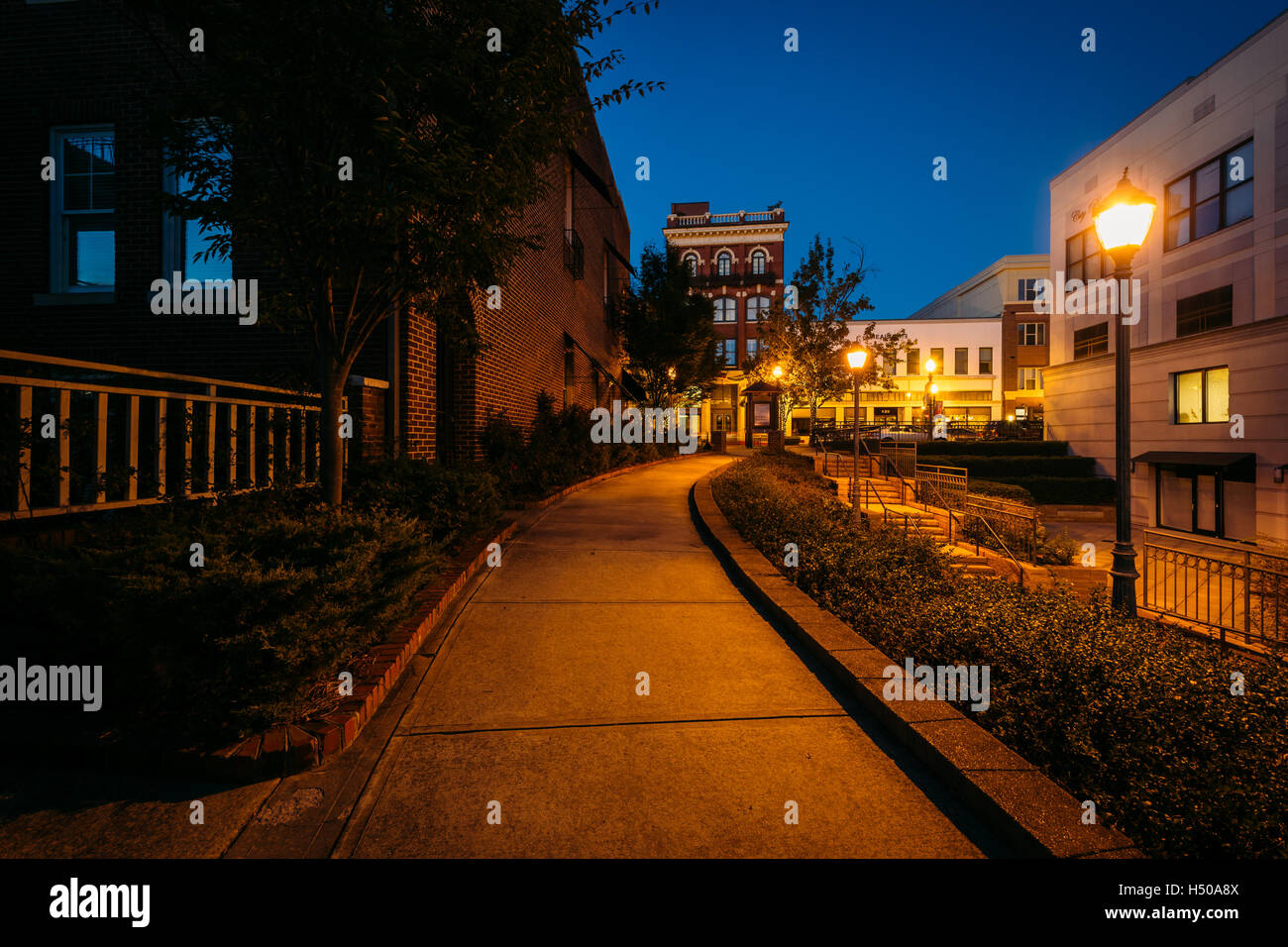 Gehweg und Gebäude in der Nacht in der Innenstadt von Rock Hill, South Carolina. Stockfoto