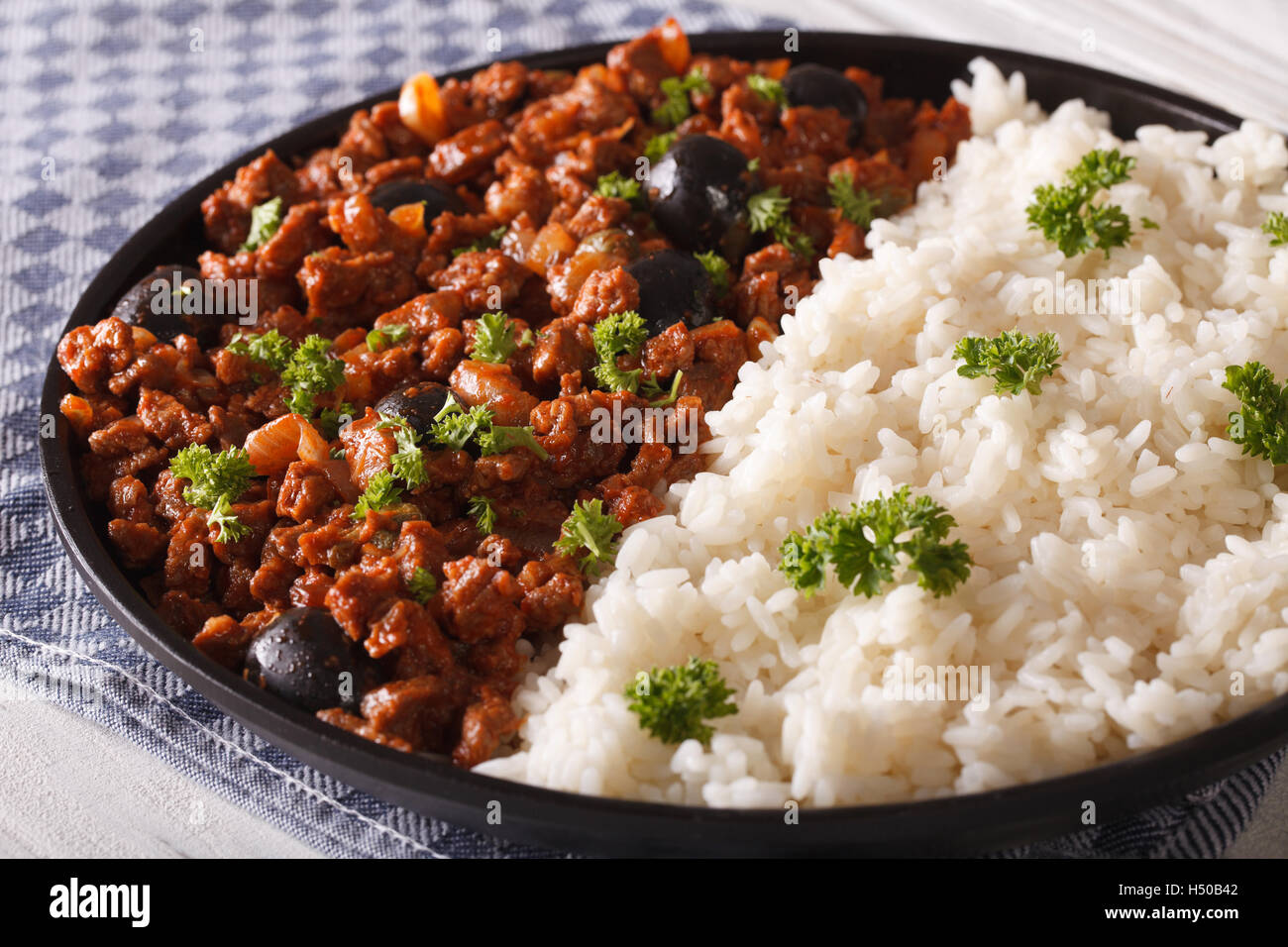 Kubanische Küche: Picadillo à la Habanera mit als Beilage Reis Nahaufnahme auf einer Platte. horizontale Stockfoto